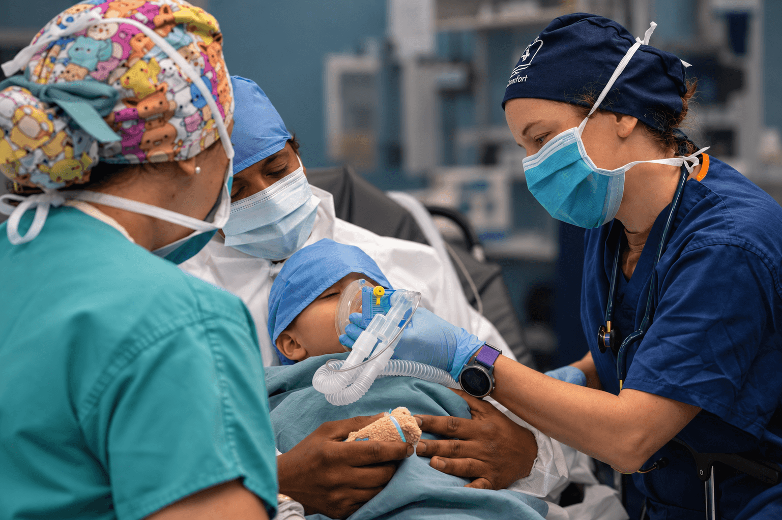 Anesthesia care team supporting a child during mask induction.